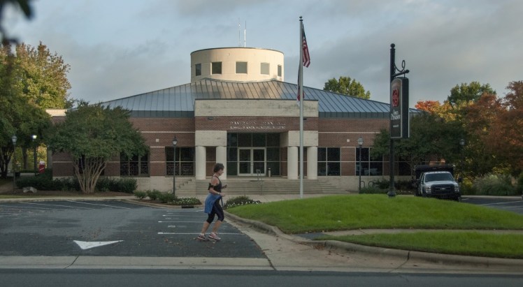 A jogger passes Town Hall, which  under one scenario, would be torn down to make way for apartments, offices and shops. But the idea is still far from a done deal - there's no developer or financing for it.   (David Boraks photo)
