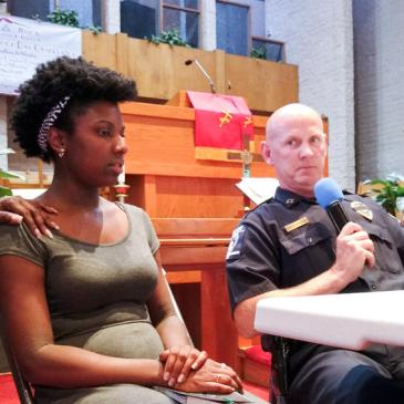 Aryana Crawford sits next to CMPD Capt. Chuck Henson at Wednesday's NAACP forum at Little Rock AME Zion Church. (David Boraks/WFAE)